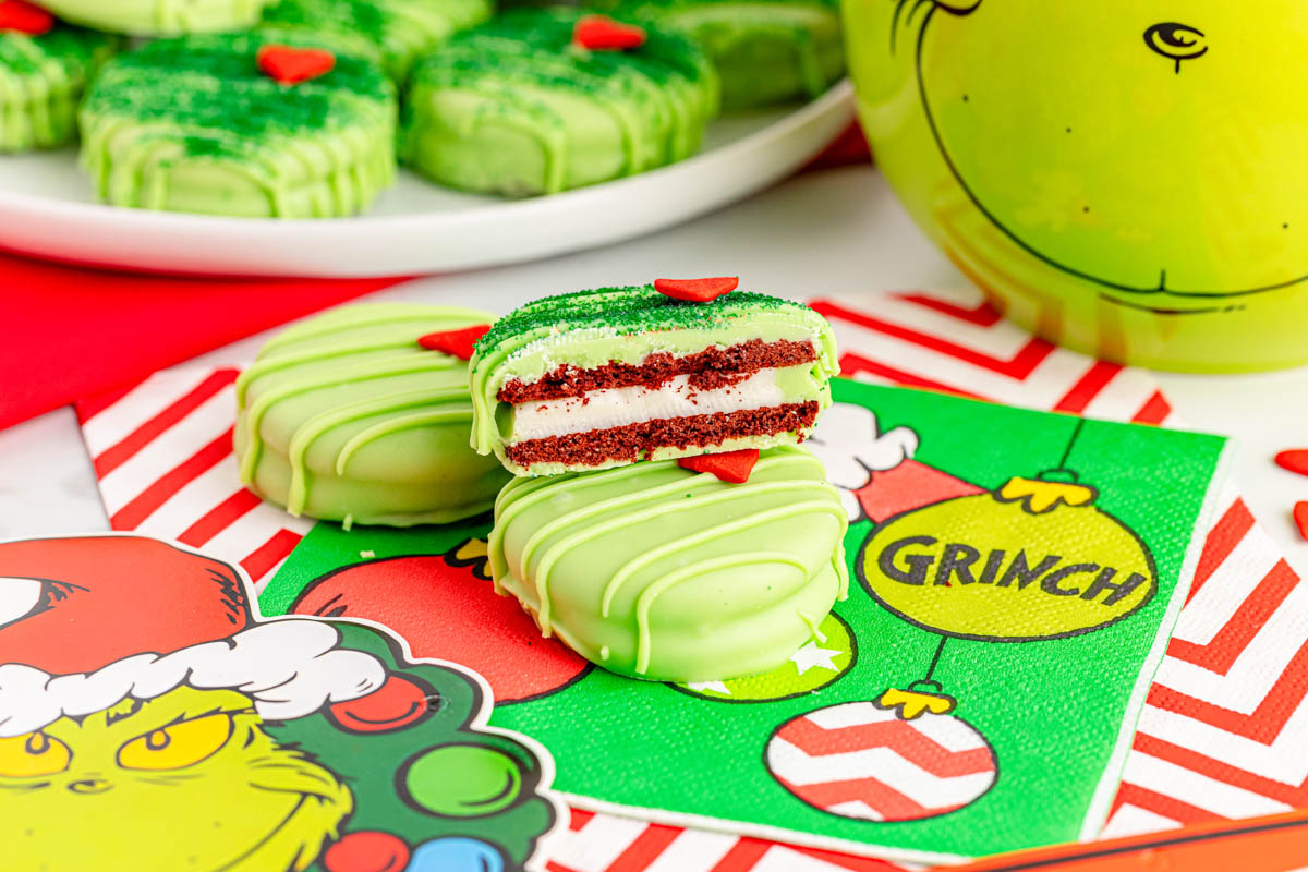 The grinch cookies are sitting on a table next to a Grinch decor