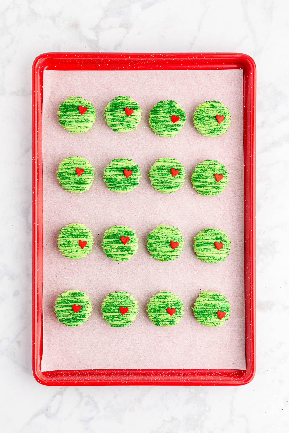 Grinch cookies on a red tray.