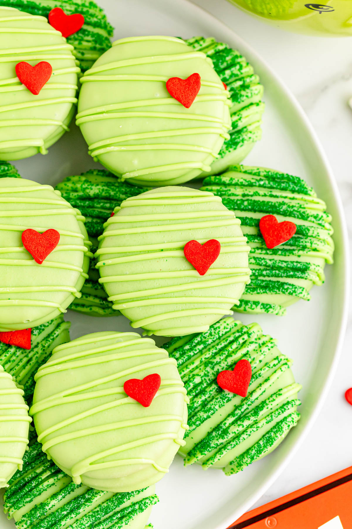 Grinch cookies with hearts on a plate.
