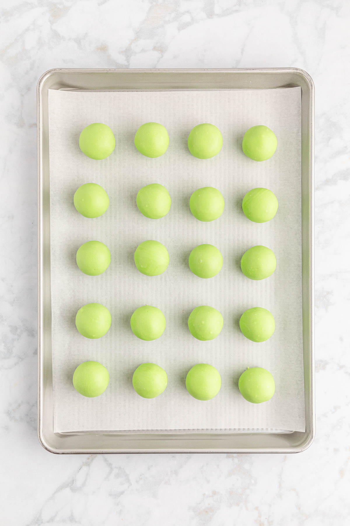 Green Oreo balls on a baking sheet.
