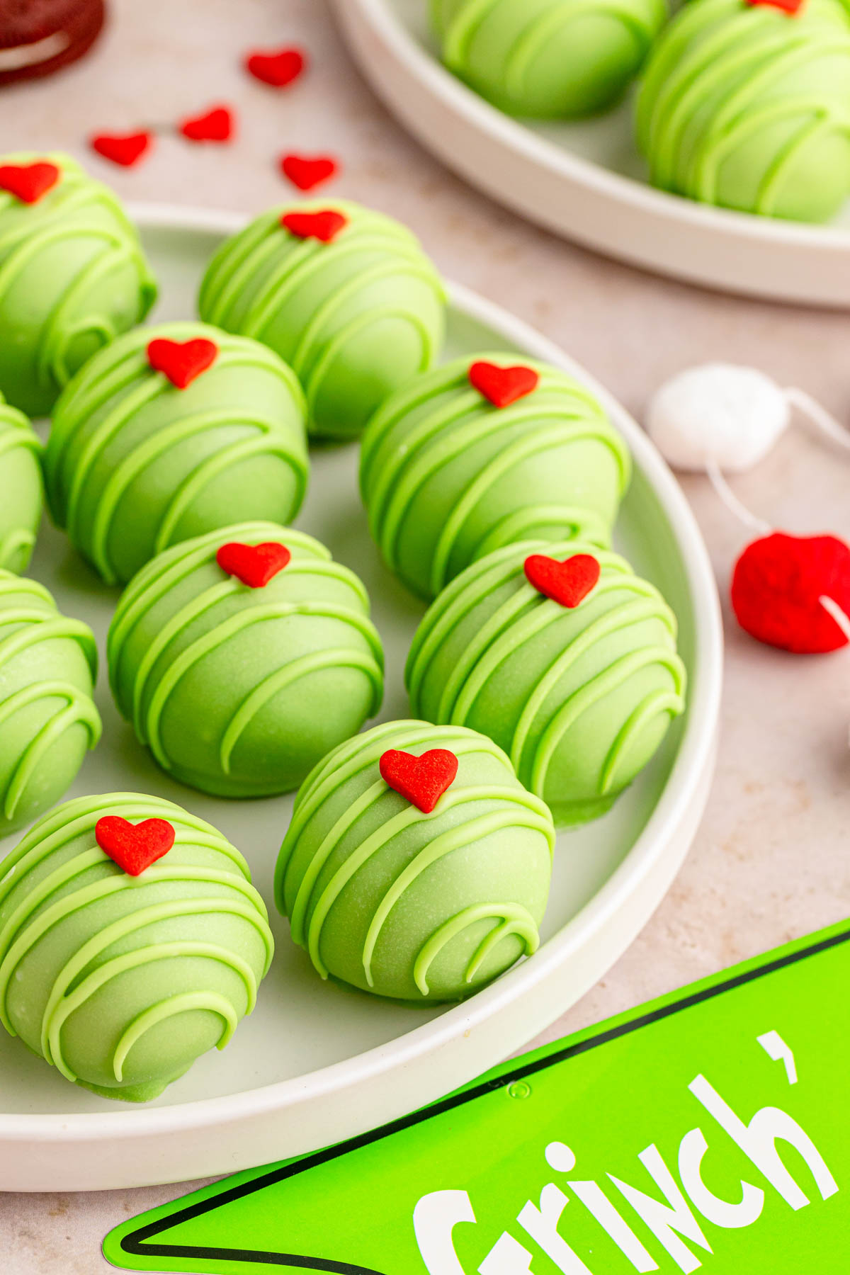 A plate of green Oreo balls with a heart on top with Grinch decor