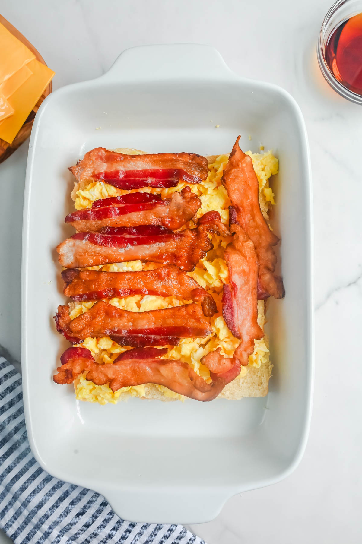 Bacon and eggs in a white baking dish.