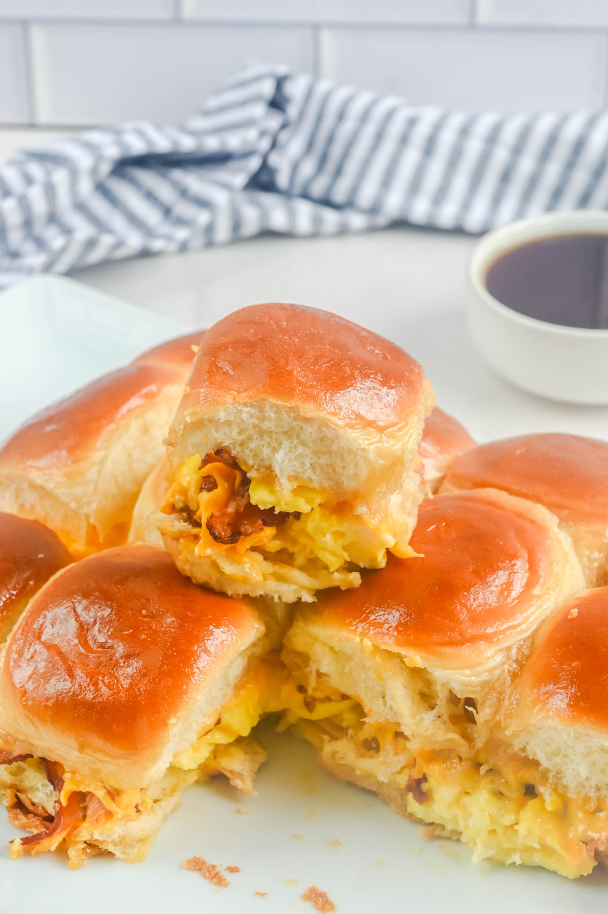 Breakfast sliders on a plate with a cup of coffee.