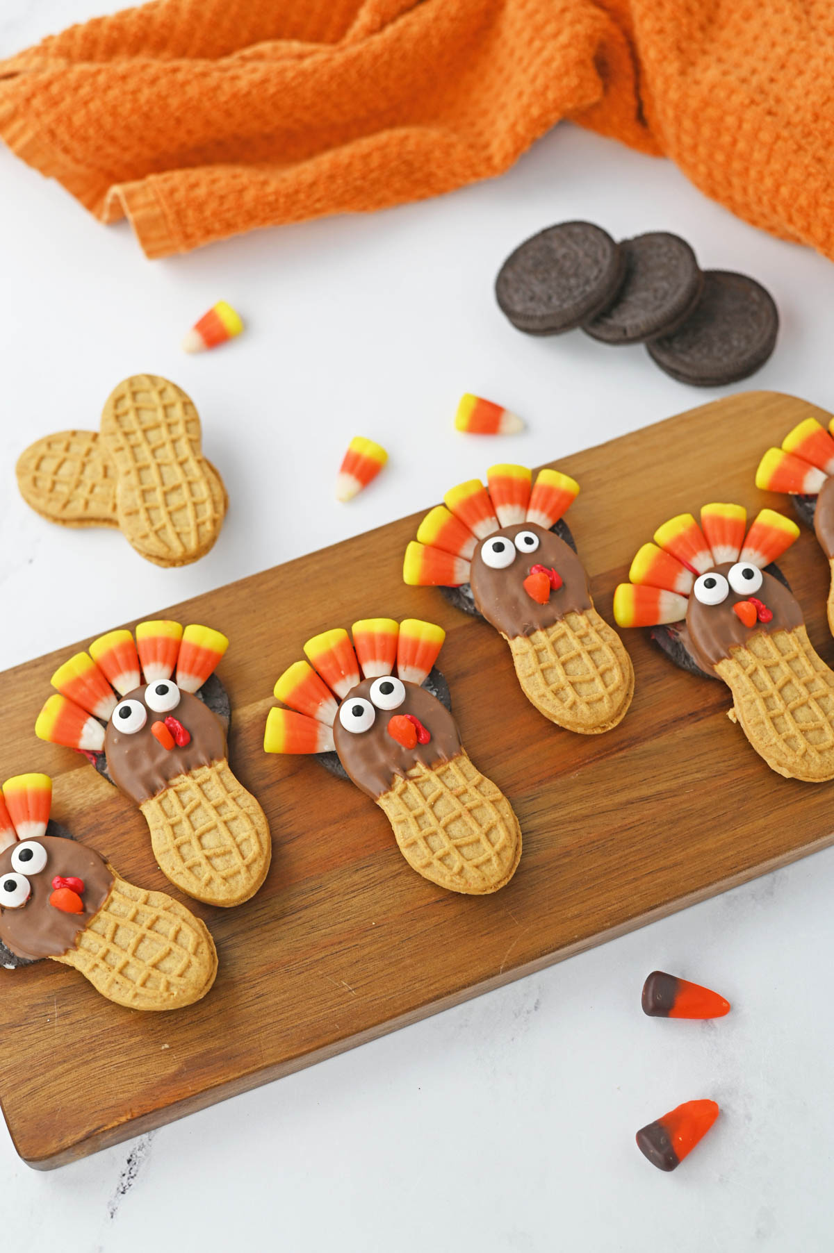 Thanksgiving turkey cookies on a wooden cutting board.