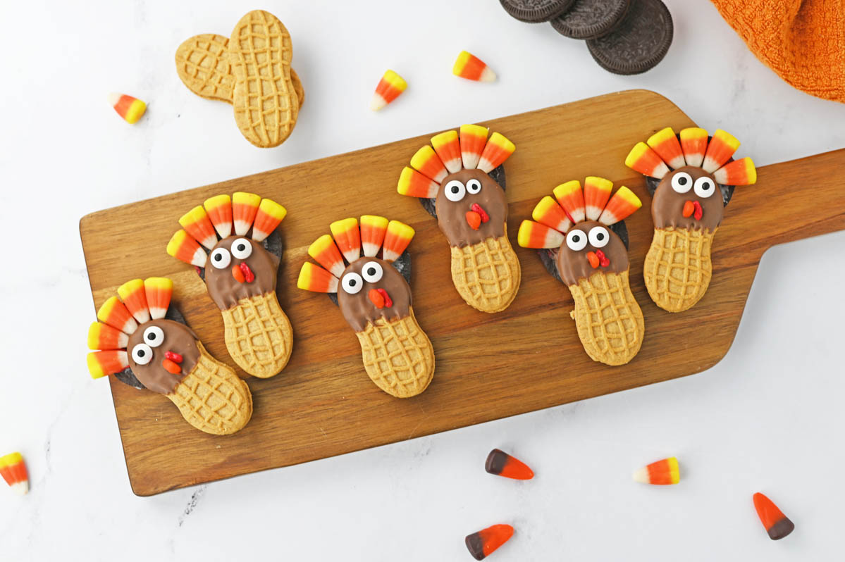 Thanksgiving turkey cookies on a wooden cutting board.