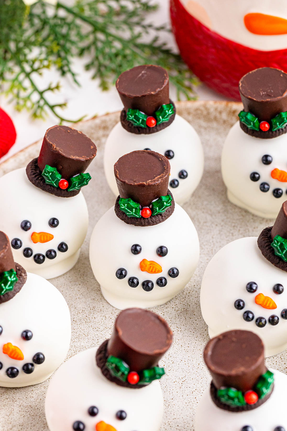Snowman cookies with chocolate hats on a plate.