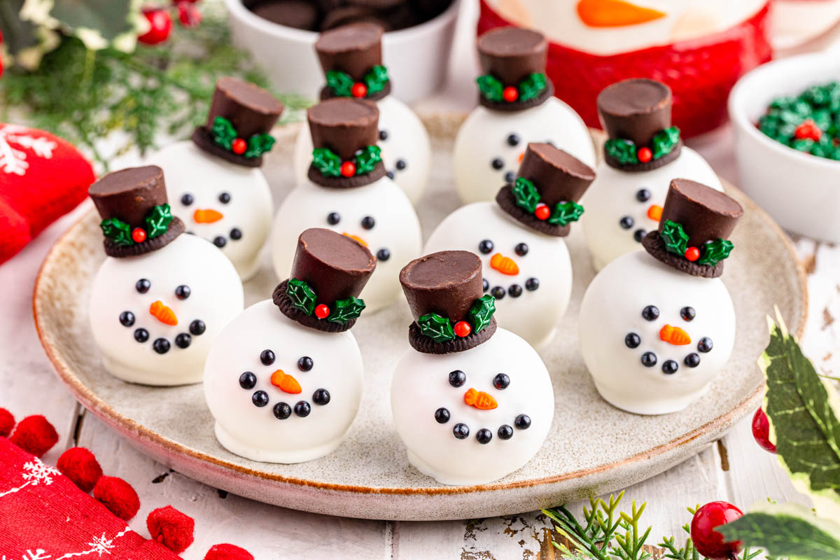 A plate of snowman shaped chocolate cookies on a table.