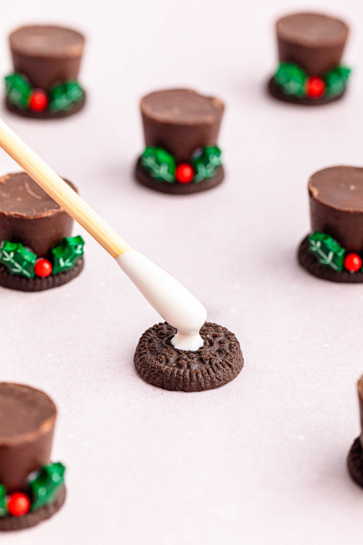 Oreo cookie top hats with holly leaves.