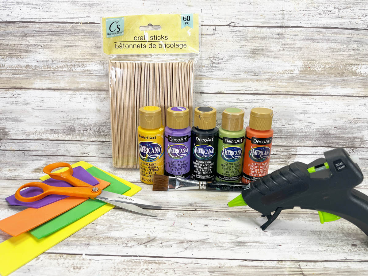 A craft kit with paint, glue, scissors, and a glue gun.