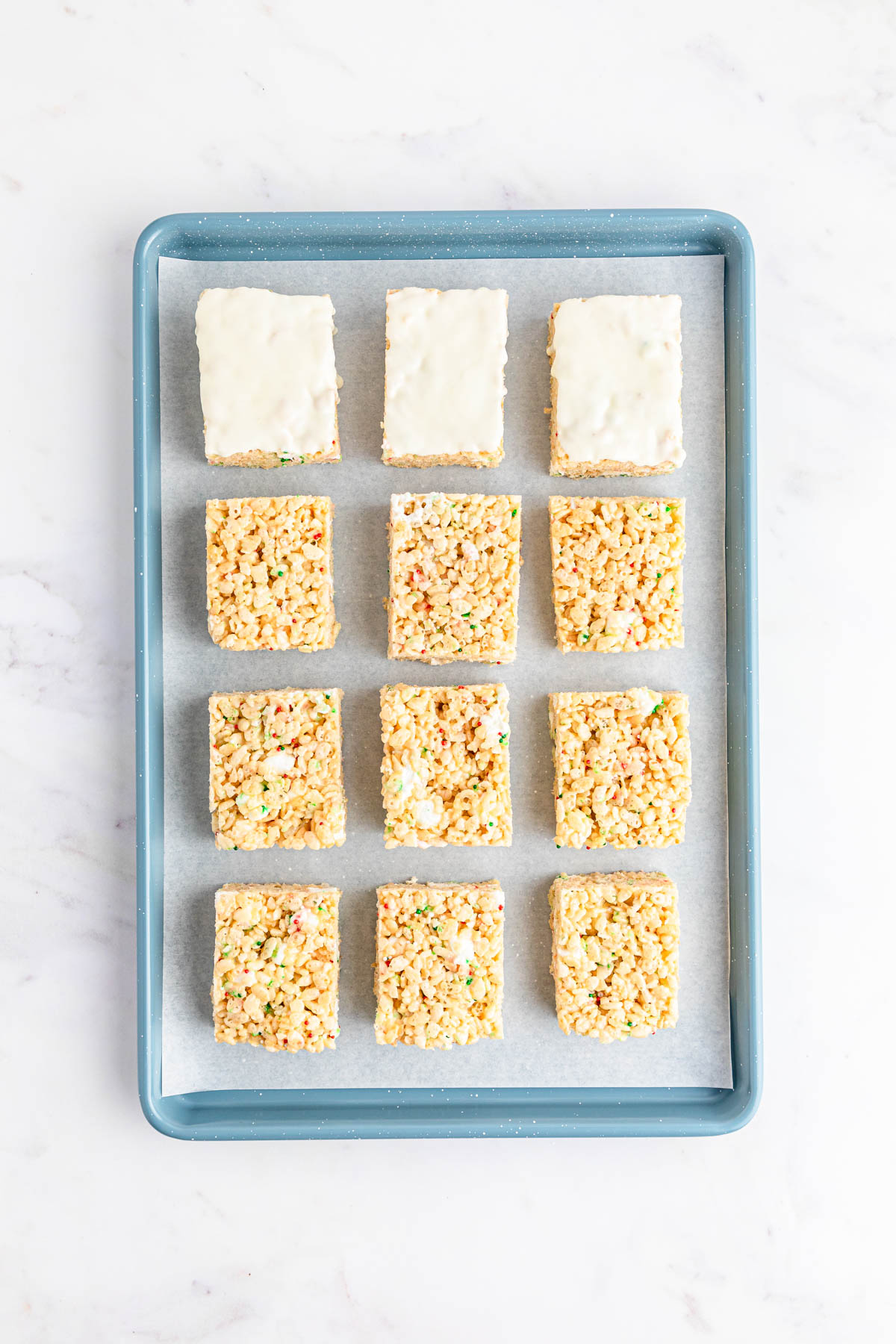 Rice krispie squares on a blue tray.