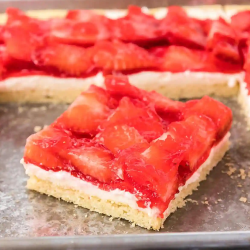 Strawberry cheesecake bars on a baking sheet.