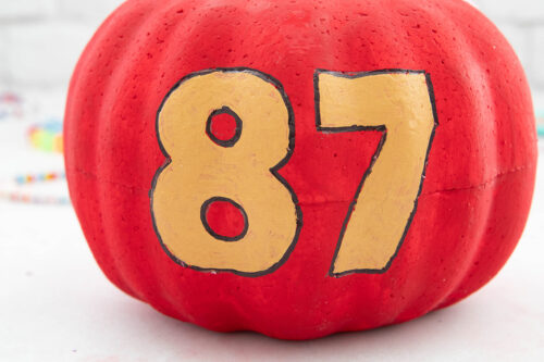 A pumpkin with the number 77 painted on it.