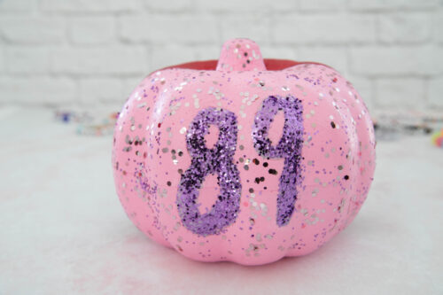 A pink pumpkin with the number eight on it.