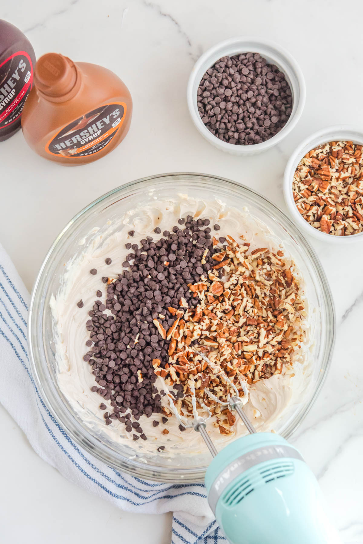 Cream cheese mixture in a bowl with nuts and chocolate chips.