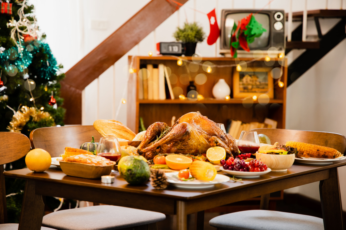 A wooden table with a turkey and other food on it