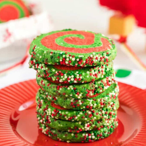 A stack of christmas cookies on a red plate.