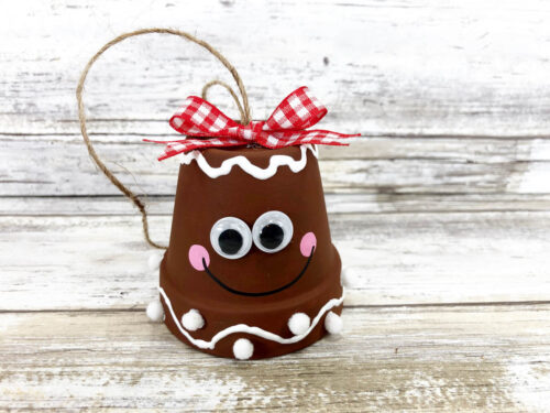 A gingerbread ornament with a smiley face on it.