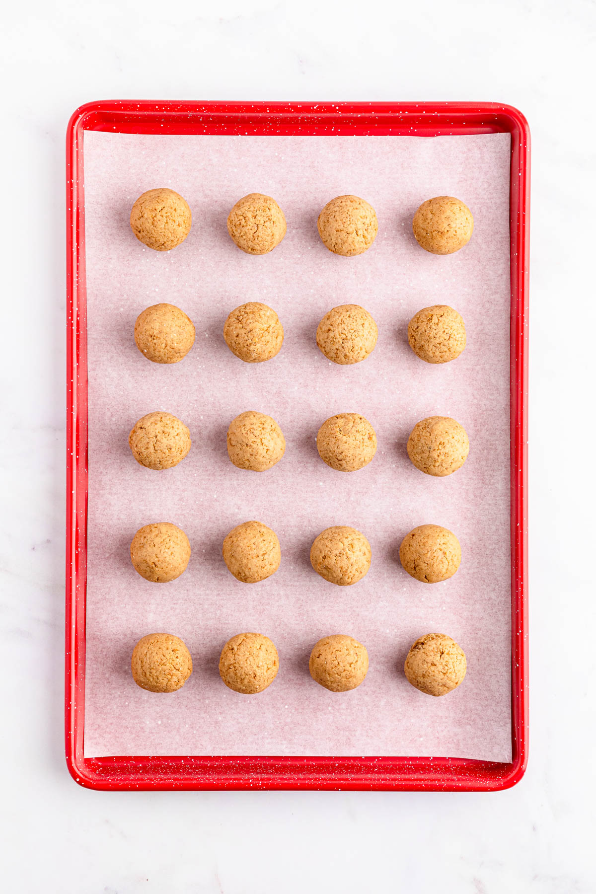 A baking tray filled with gingerbread balls.