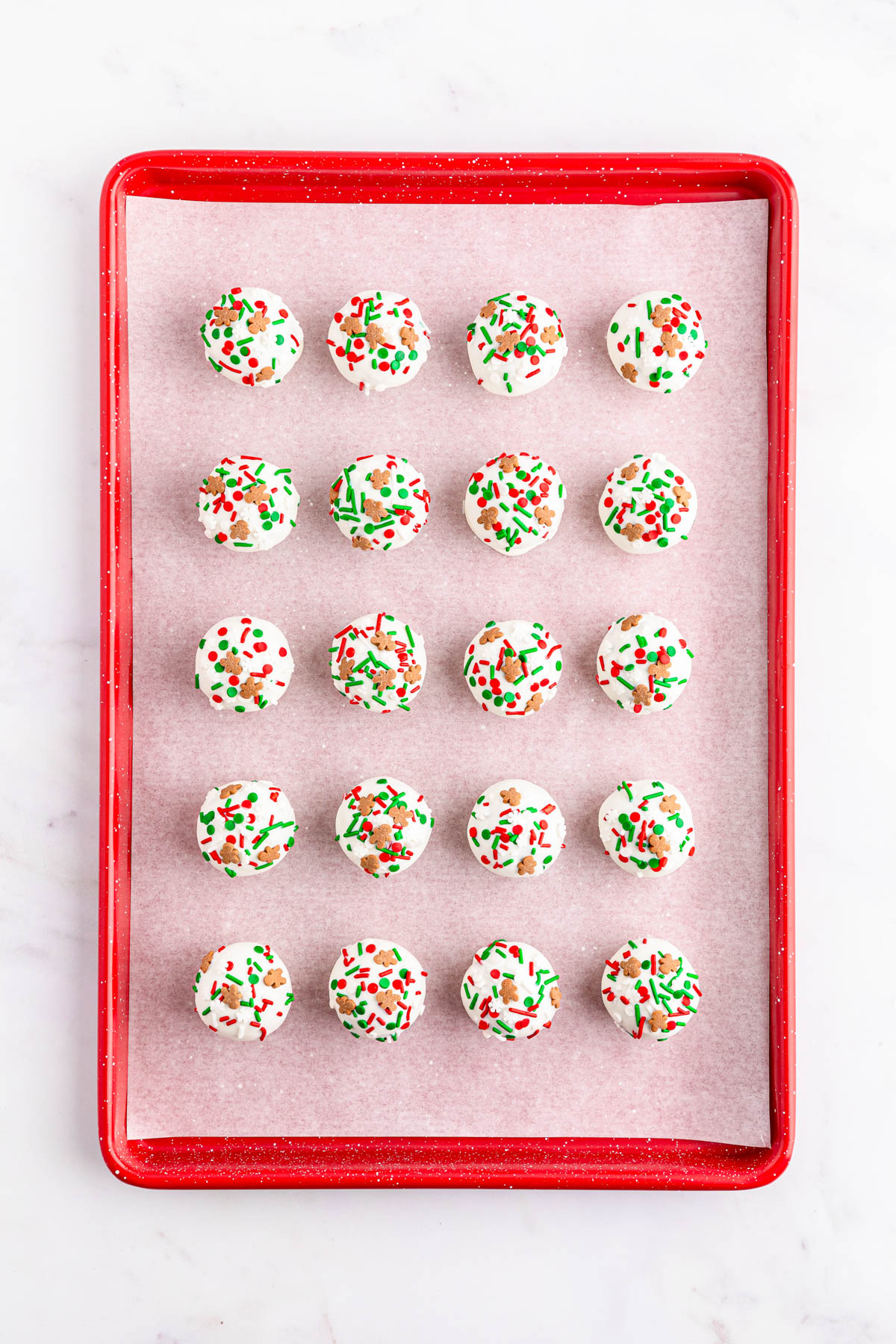 A tray full of Christmas truffles with sprinkles on them