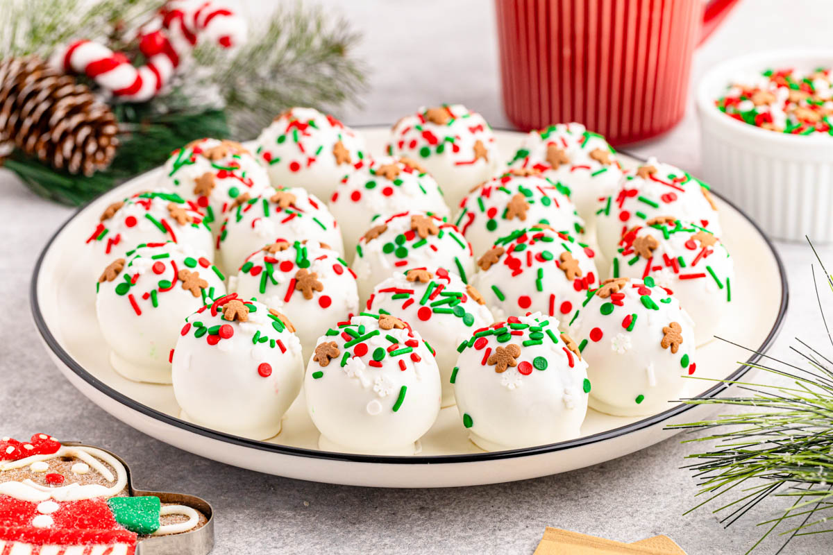 A plate of white chocolate covered gingerbread balls with sprinkles.