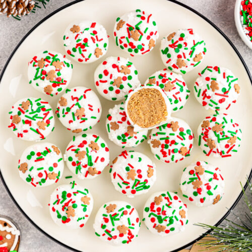 A plate of christmas cookies with sprinkles on it.