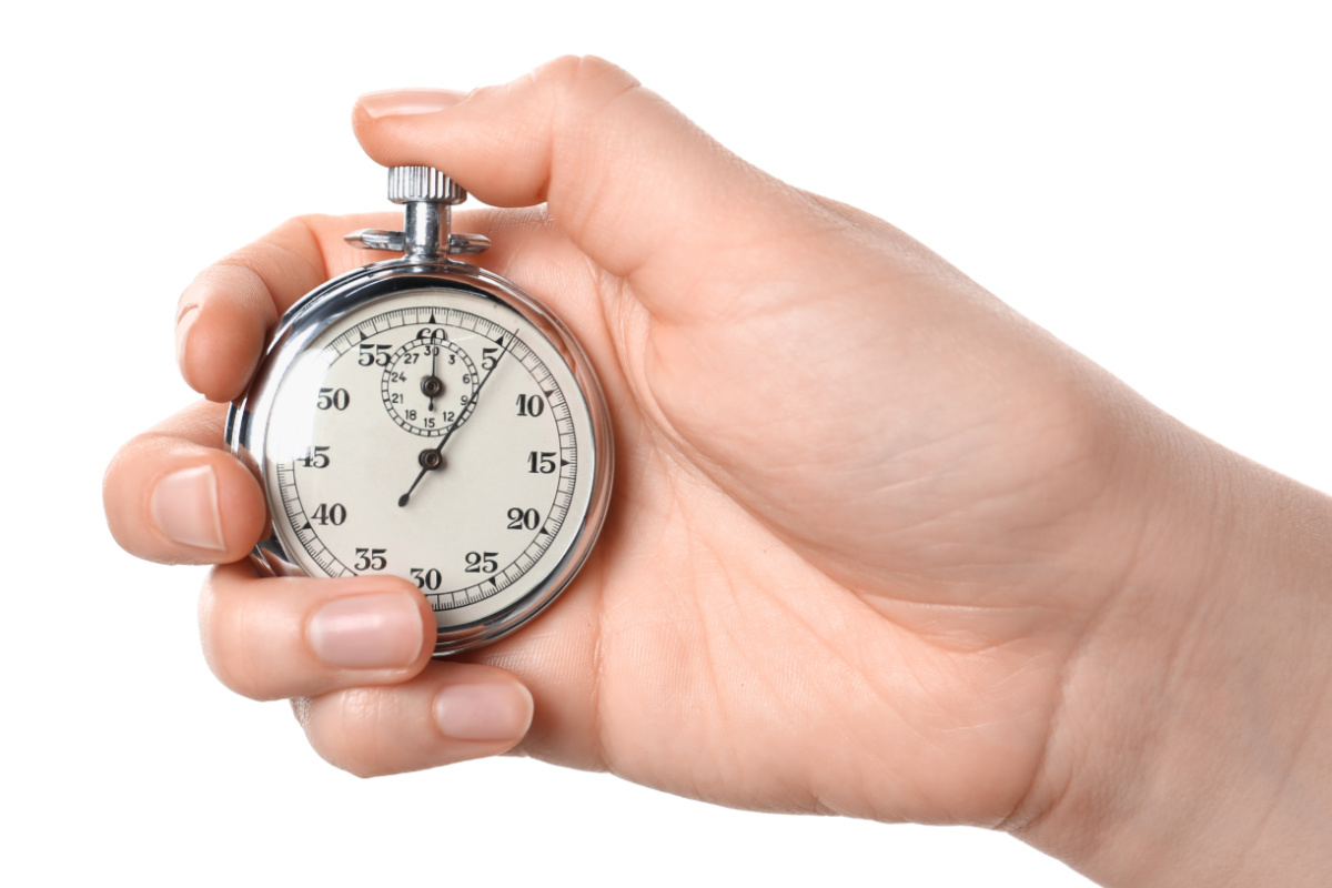 A hand holding a stopwatch on a white background.