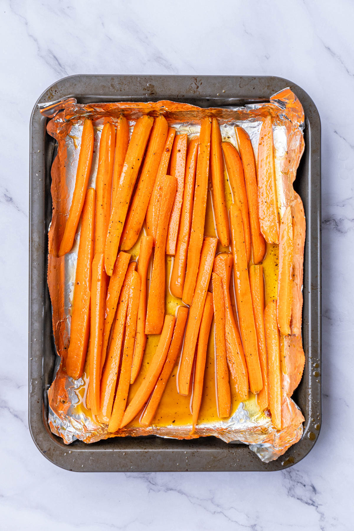 A baking pan with carrots in it.