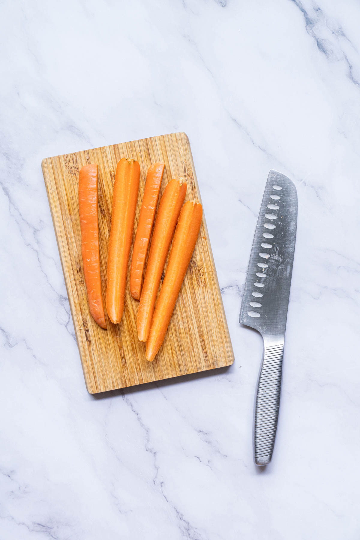 Carrots on a cutting board with a knife.