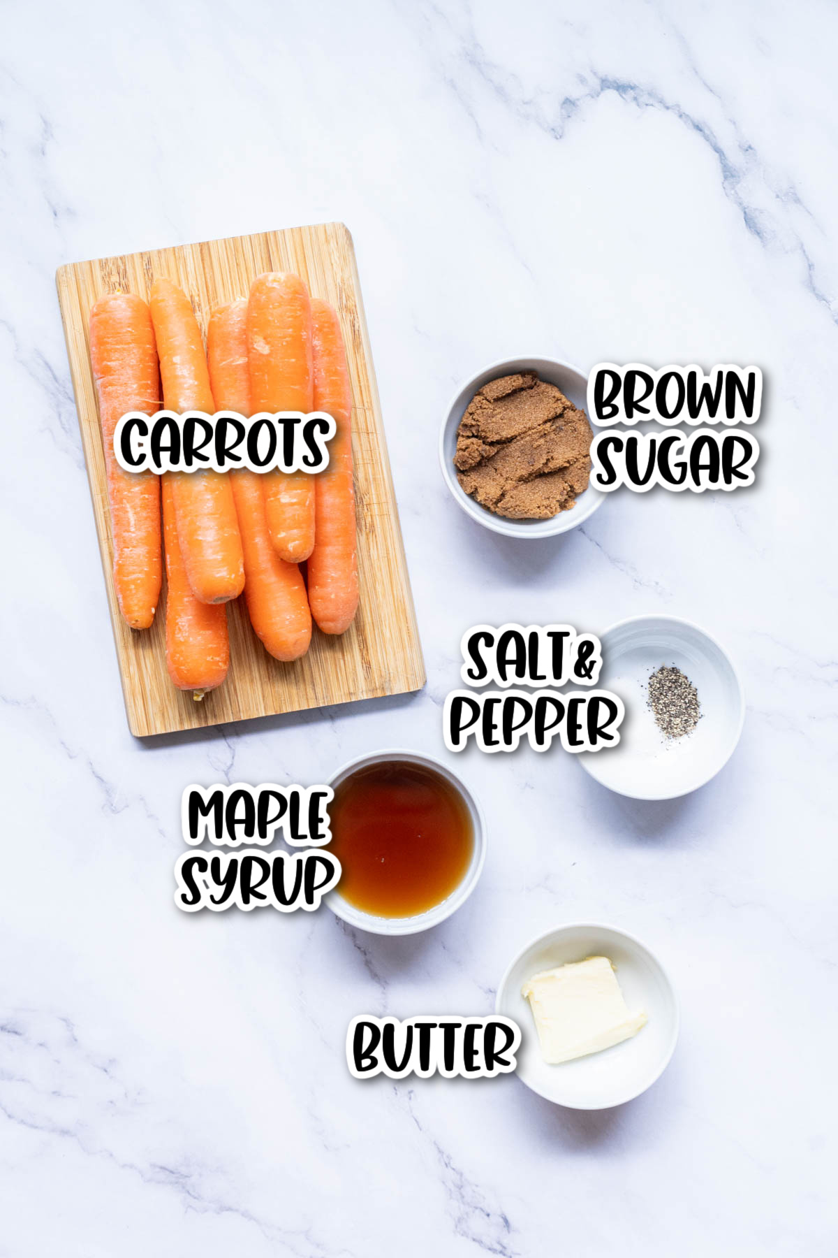 The ingredients for maple glazed carrots are shown on a marble cutting board.