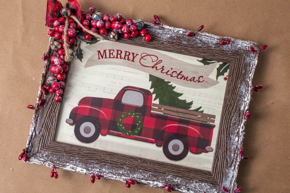 A merry christmas sign with a red truck and berries.