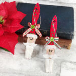Paintbrushes made into Santa ornaments leaning against book