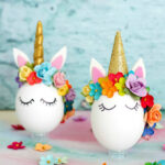 Two unicorn easter eggs with flowers on them.