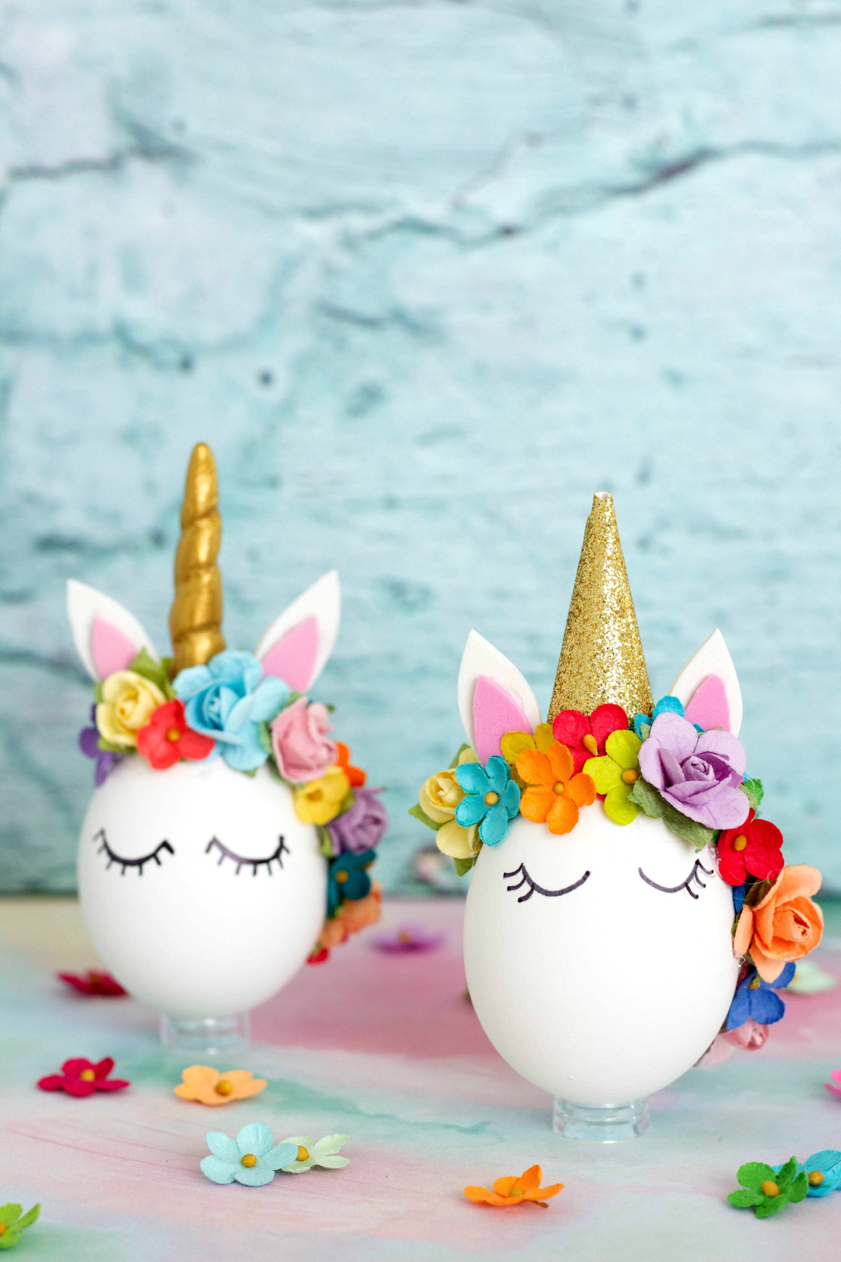 Two unicorn shaped Easter eggs with flowers on them.