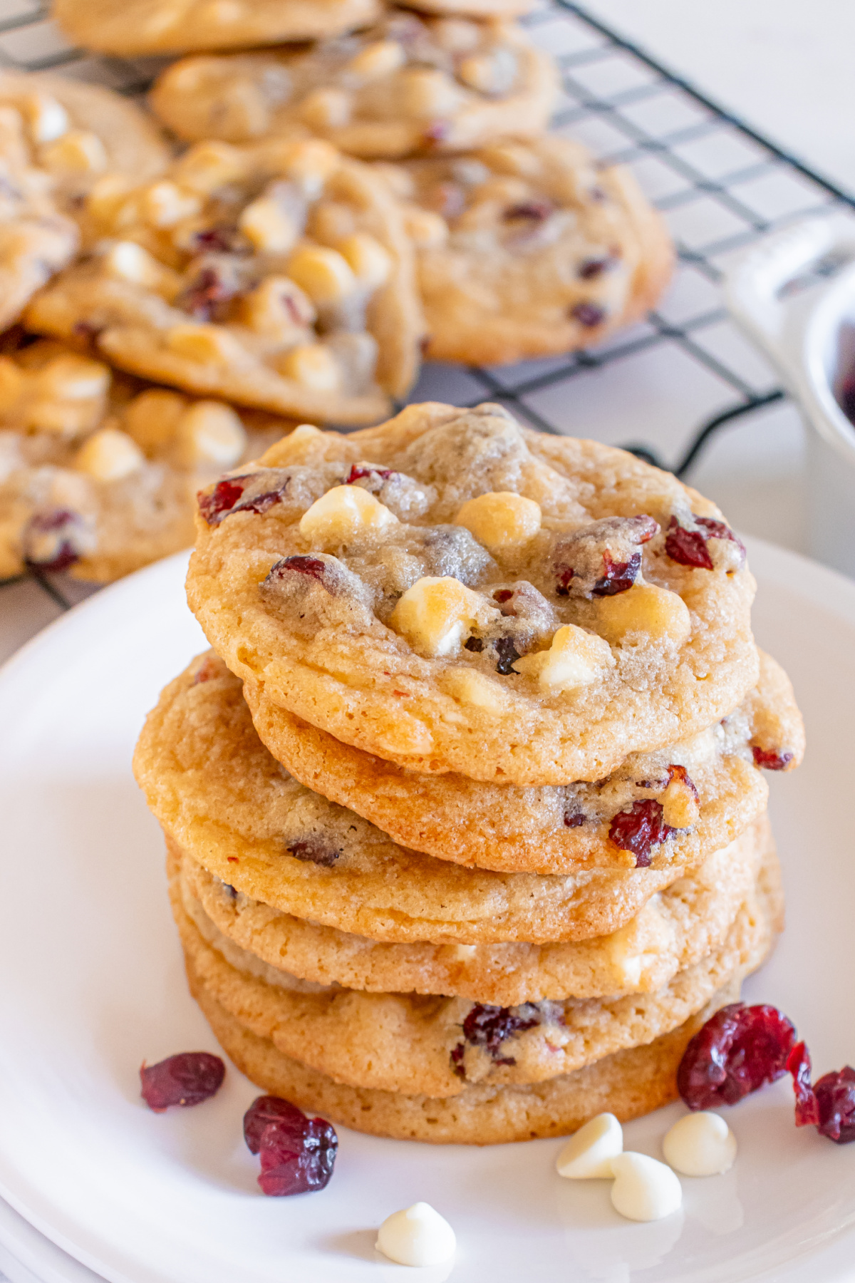 A stack of white chocolate cranberry cookies on a plate.