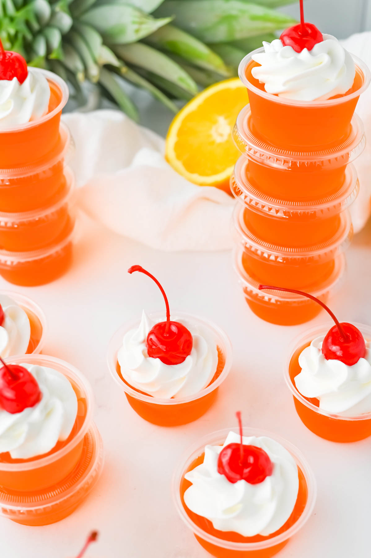Bahama mama jello shots with whipped cream and cherry on top.