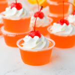 Bahama Mama jello shots with whipped cream and cherry on top.