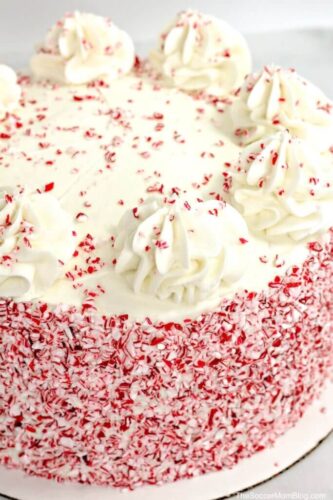 A white cake with red sprinkles on top, perfect for Christmas celebrations.