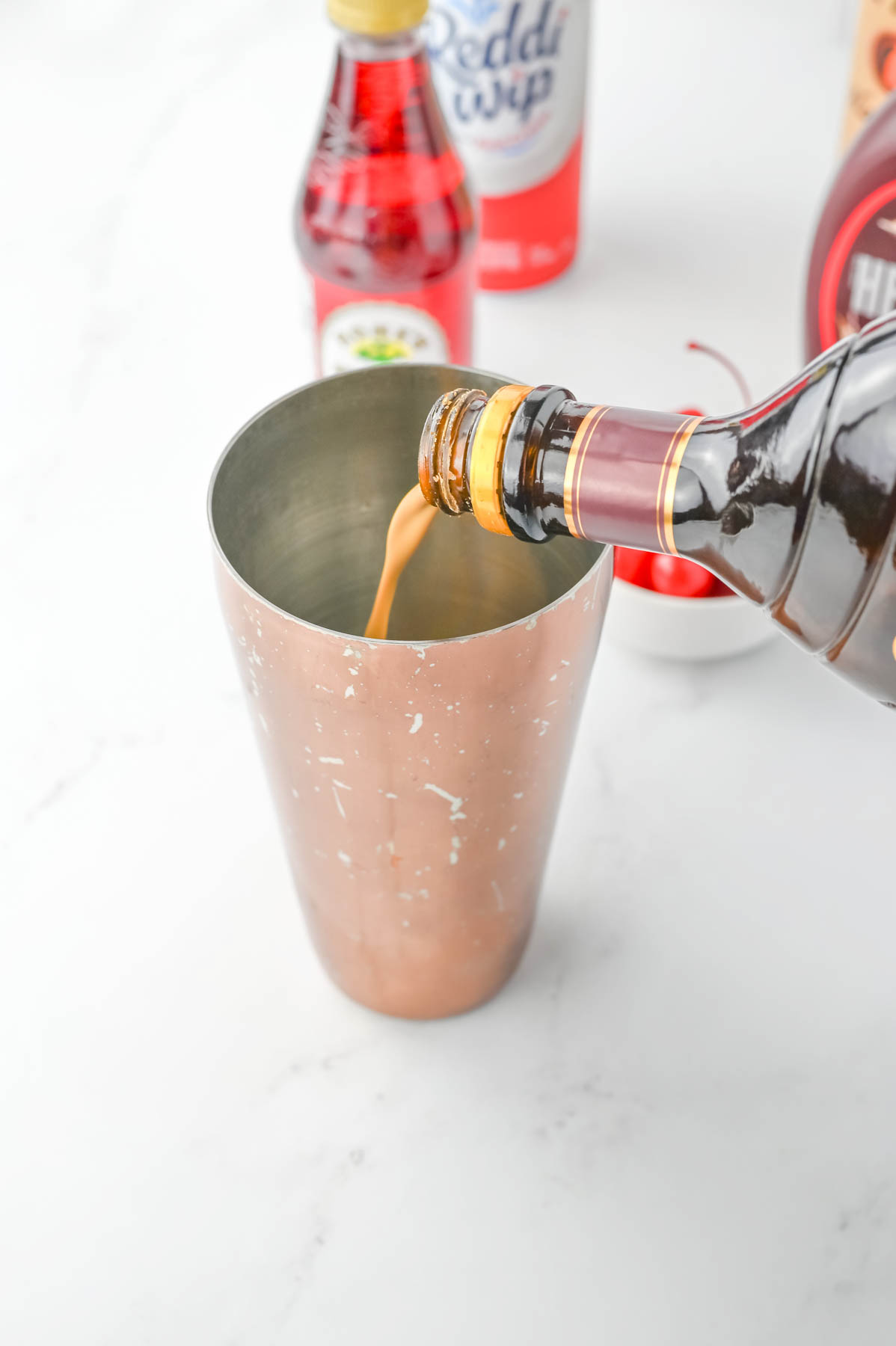 A copper cup is being filled with a drink.