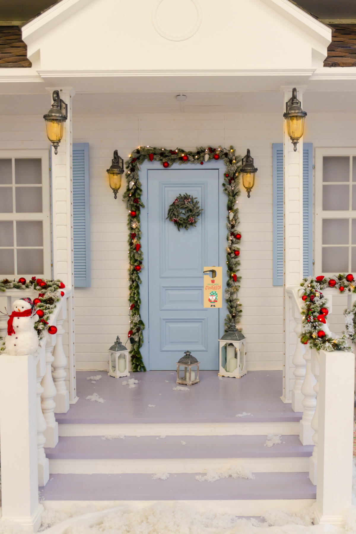A blue door with christmas decorations on the front porch.