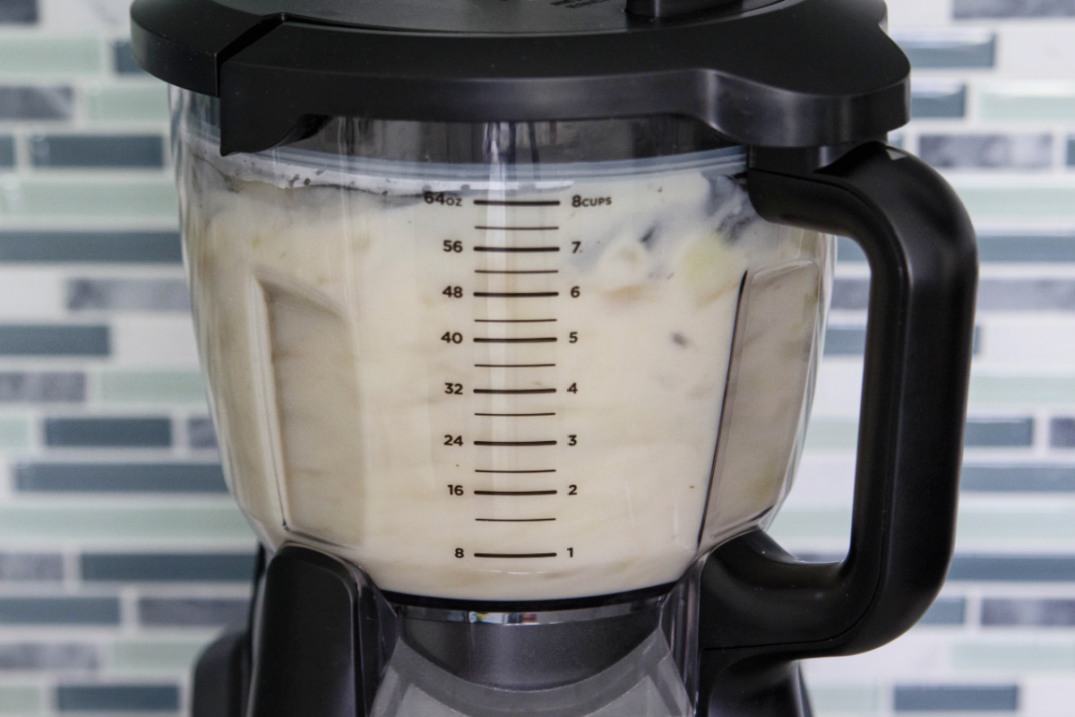 A blender filled with potatoes.