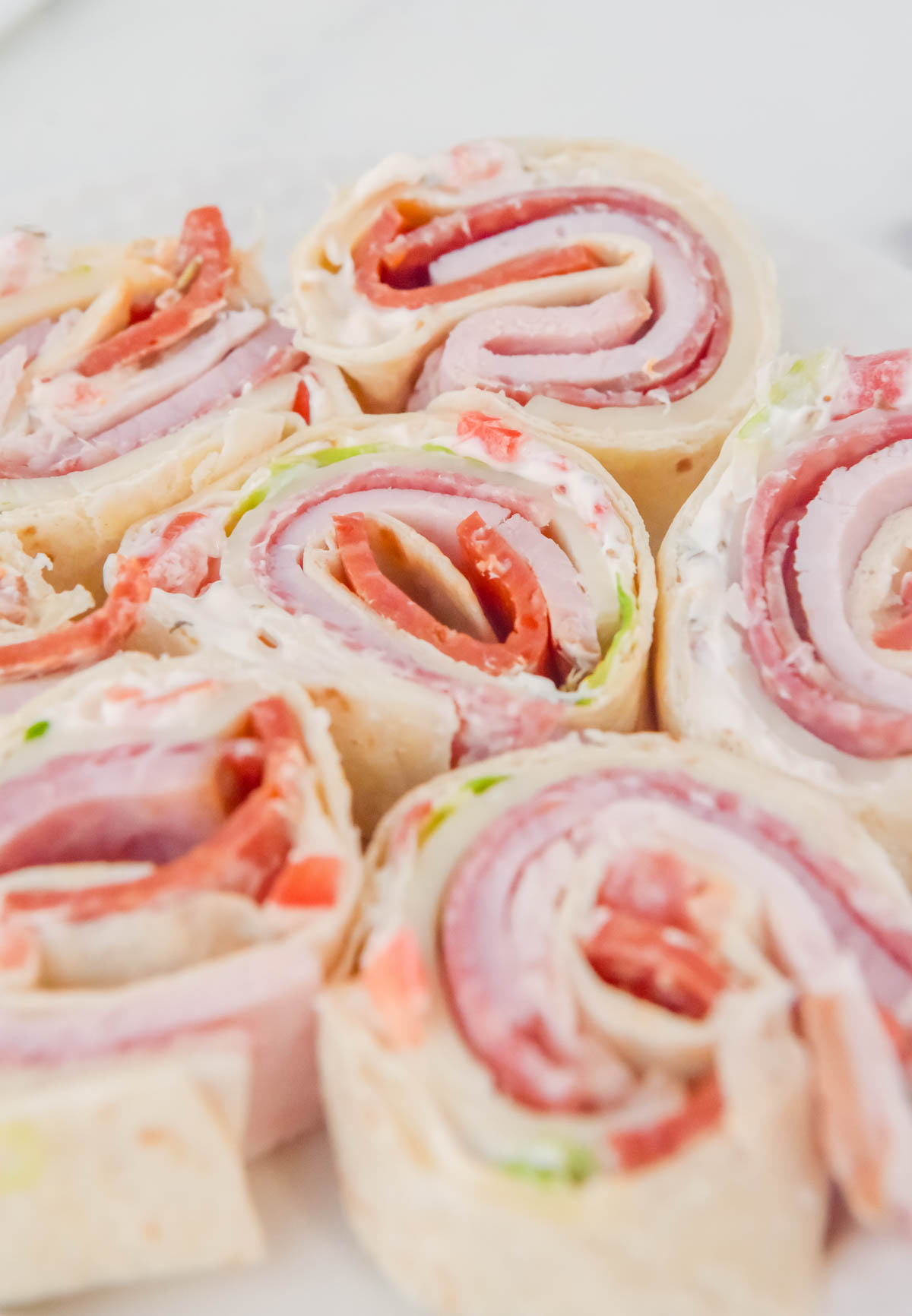 Ham and cheese roll ups on a plate.