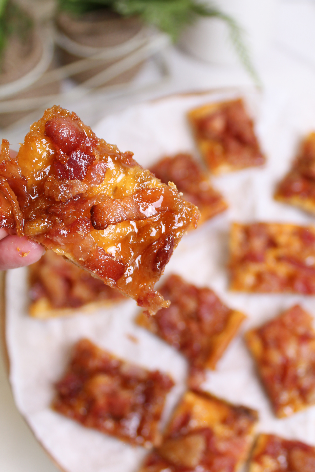 A person holding a piece of maple bacon crack