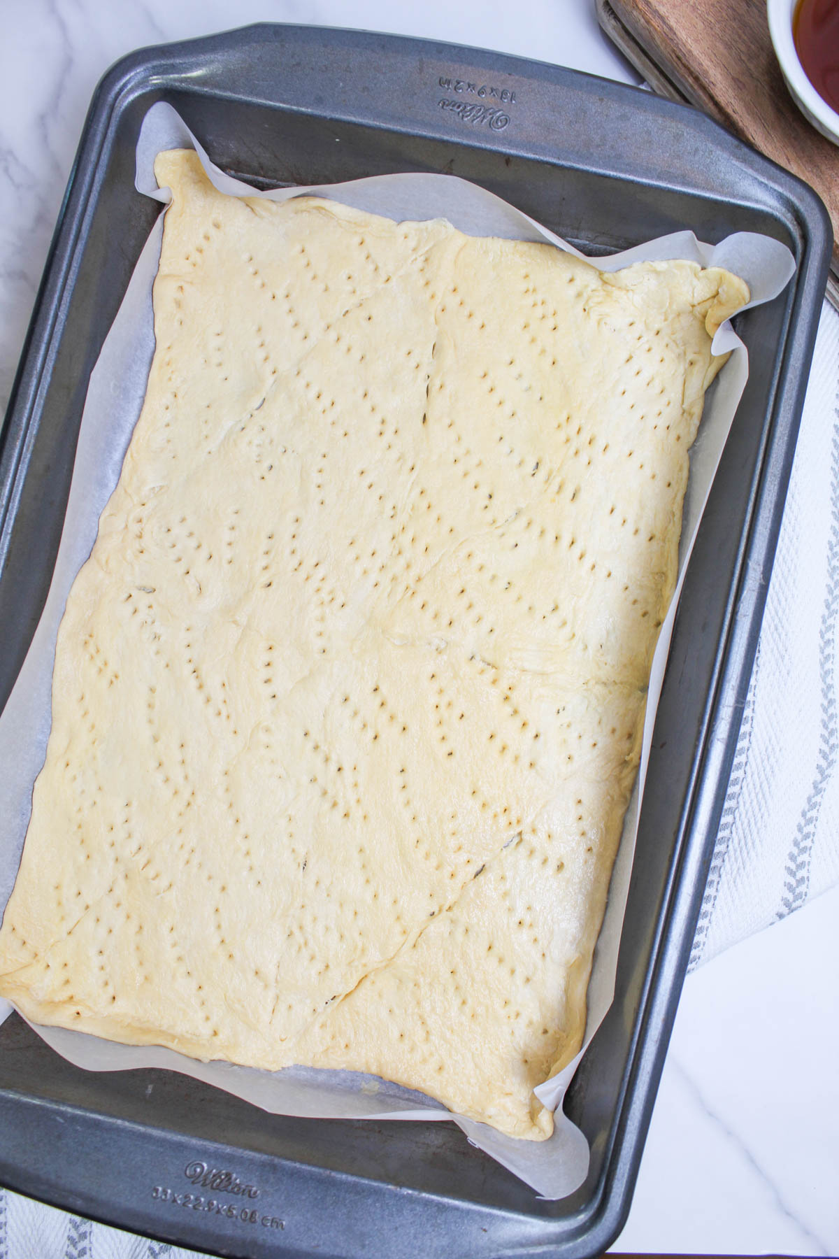 A sheet of pastry dough on a baking pan.