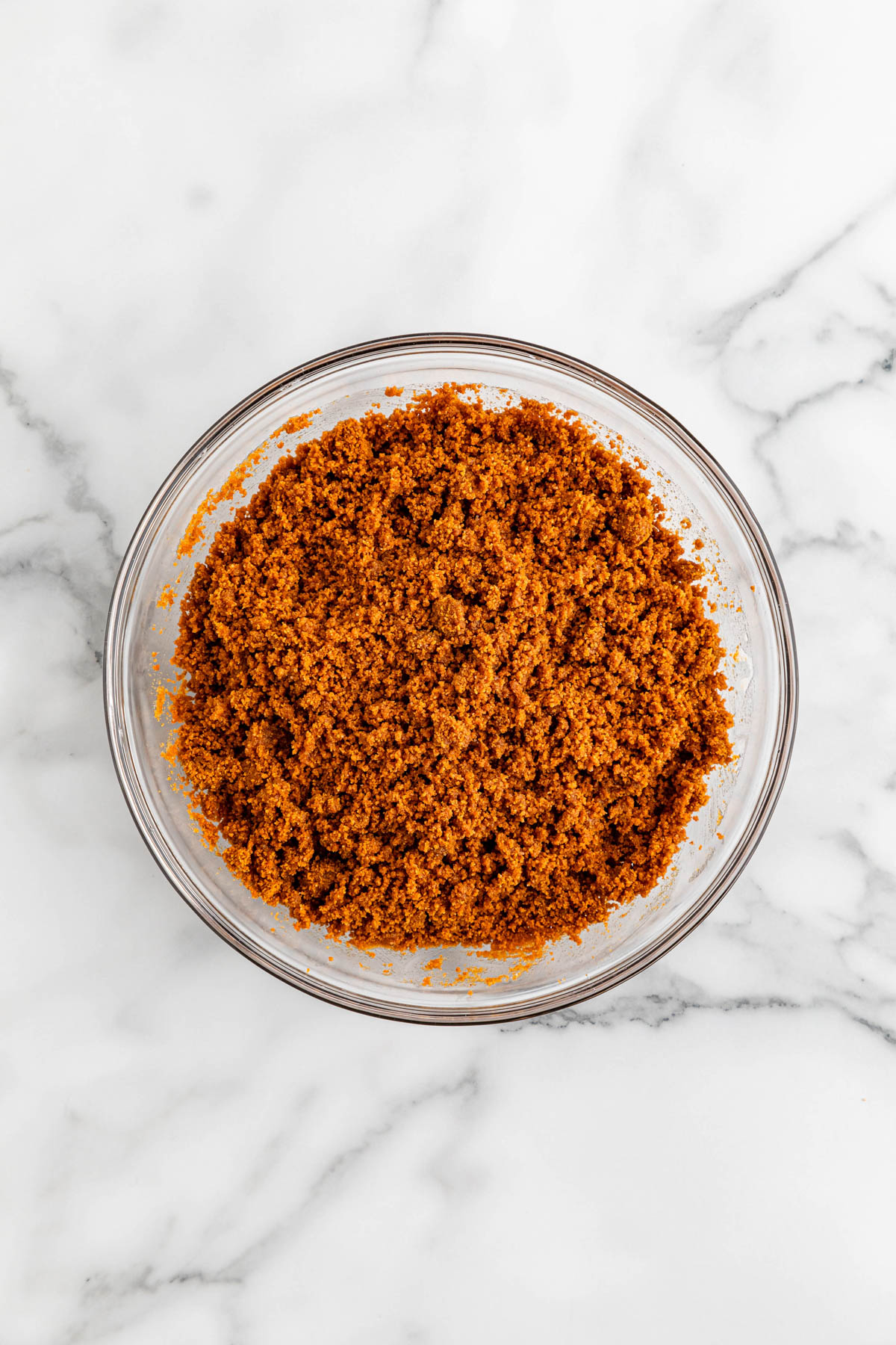 A glass bowl filled with ingredients for Biscoff crust