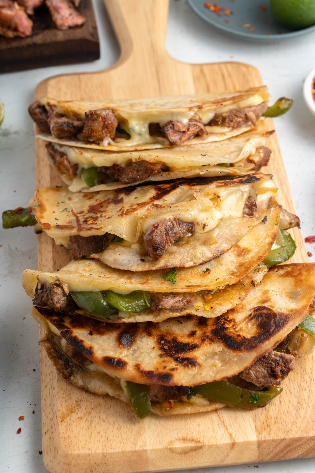 A stack of quesadillas on a wooden cutting board.
