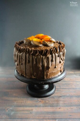 A chocolate cake with oranges on top.