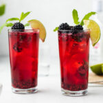 Two glasses of blackberry mojito with lime and mint.