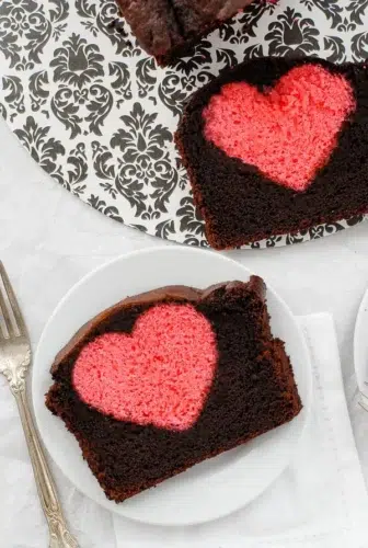A slice of chocolate cake with a heart cut out of it.