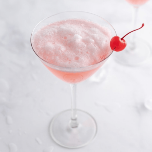 A pink martini with a cherry on top.