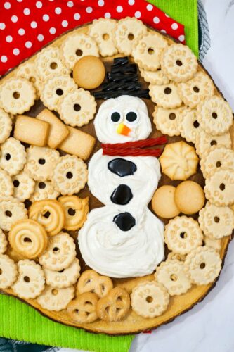 A snowman shaped cookie and crackers.